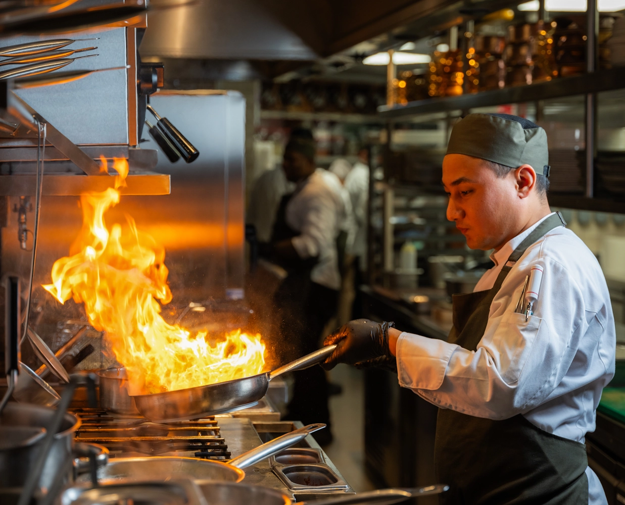 Best mediterranean cuisine in Dubai Chef preparing food with flames at Blume Restaurant Dubai