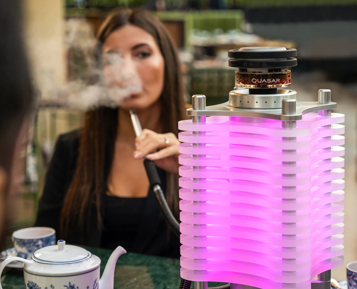 Guest enjoying shisha with purple lighting at Blume Restaurant Dubai